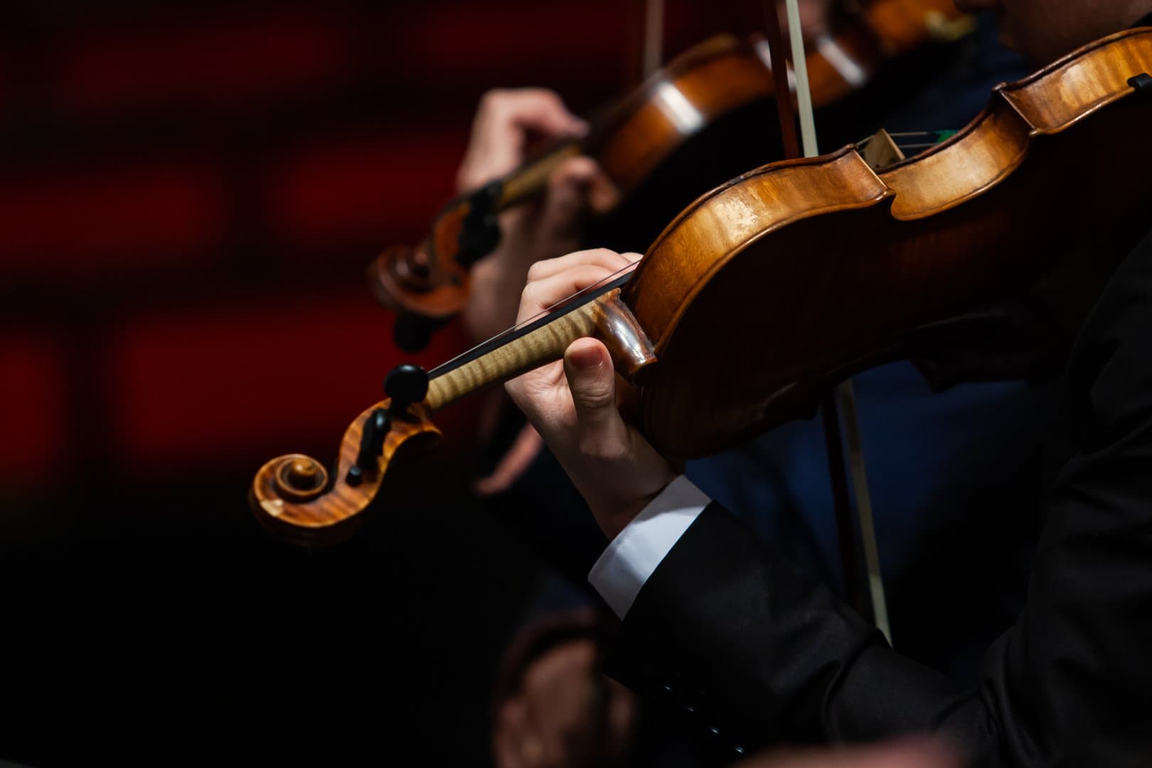 Close-up of a musician's hand playing the violin in an orchestra